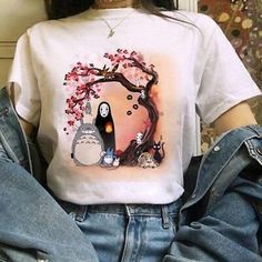 a woman wearing a t - shirt with an image of totoro and cat on it