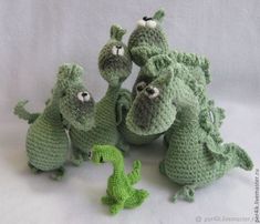 green crocheted toys are arranged on a white surface