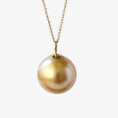 This is a gorgeous pendant with a gorgeous genuineGolden South Sea pearl, set with a 14K yellow gold bail. The round pearl is 13-14mm, making it a real statement piece. The pearl's color is light golden with green overtone, a high luster and a clean surface, making it a perfect addition to any jewelry collection. The pendant comes with a high quality 14K yellow gold-filled chain, made in Italy. Each jewelry piece is unique, one of one, handmade in my California studio, and individually photograp Gold Pearl Necklace With High Luster Round Pendant, Gold Plated Round Pearl Pendant Jewelry, Yellow Gold Pearl Pendant Necklace With High Luster, Gold-tone Pearl Pendant Necklace, High Luster Yellow Gold Pearl Pendant Necklace, Yellow Gold High Luster Pearl Pendant Necklace, Yellow Gold-plated Jewelry With Pearl Pendant, Yellow Gold Pear-shaped Pearl Necklace With High Luster, Pear-shaped High Luster Yellow Gold Pearl Necklace