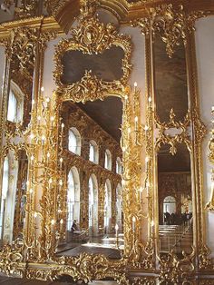 an ornately decorated wall with mirrors and chandeliers in the middle of it