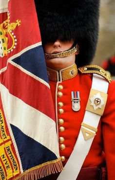 the british flag is being carried by a man in uniform