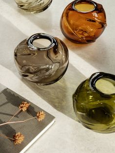 three glass vases sitting on top of a table