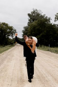 Groom walks away carrying bride over his shoulder as he celebrates with a fist in the air while bride flashes a smile and shows off her stunning wedding ring. Unique Wedding Poses, Fun Wedding Pictures, Wedding Couple Photos