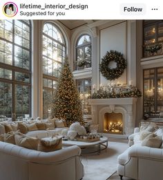 a living room filled with white furniture and a christmas tree in the middle of it