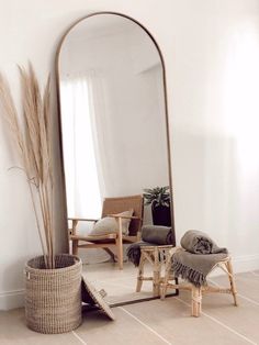 a large mirror sitting next to a chair on top of a floor in a room