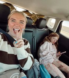 a woman sitting in the back seat of a car with her toothbrush in her mouth