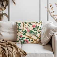 a white couch with a decorative pillow on top of it next to a potted plant