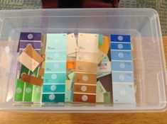 a plastic container filled with lots of different colored papers