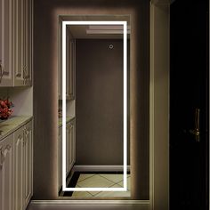 a bathroom with a large mirror on the wall next to a sink and counter top