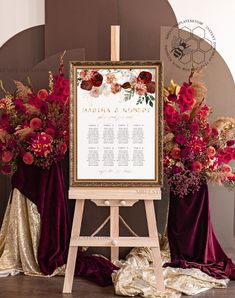 an easel with a sign and flowers on it