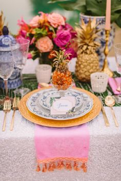 the table is set with pineapples, plates, and other decorative items on it