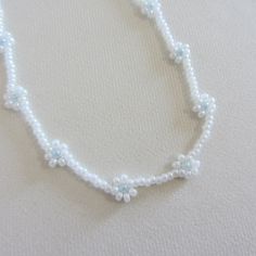 Daisy seed bead necklace with blue white flowers white beaded choker necklace gift for woman gift for kids girl Summer Necklace Boho Jewelry Measure the length of your neck with a measuring tape or you can use any thread, rope, or cable for telephone and after apply the measurements to a regular ruler. Choker is 12 inches with a 2 inches adjustable extender chain. 14 inches full length. Summer White Beaded Flower Necklace, Blue Beaded Flower Necklace As Gift, Handmade Blue Flower Beaded Necklace, White Flower-shaped Beaded Necklace, Blue Flower-shaped Beaded Necklace Gift, Summer Necklace, Beaded Choker Necklace, Seed Bead Necklace, Beaded Choker