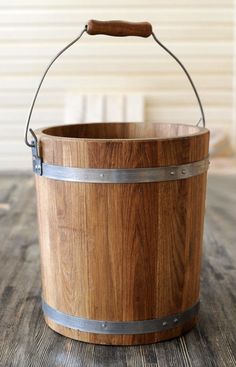 a wooden bucket with metal handles on a table