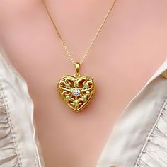 This silver 18 carat gold vermeil heart locket is inspired by the romance of a by-gone era. Made in sterling silver 925 and electro plated with 1 micron of 18 carat gold, the locket is crafted with small natural emeralds and with a micro diamond small heart inset. Hinged, it opens so you can keep your treasured photos close to your heart.  A thoroughly thoughtful gift for a special woman, this gorgeous silver gold plated heart-shaped locket is destined to be cherished eternally. Available with different length silver gold vermeil chains. Width: 21 mm.  Height: 27 mm.   Available in sapphire Intricate Design Pendant Locket Necklace For Anniversary, Elegant Gold Plated Locket Necklace For Anniversary, Elegant Medallion Heart Necklace As A Gift, Victorian Heart Pendant Locket Necklace For Anniversary, Heart-shaped Hallmarked Locket Necklace Gift, Gold Plated Heart Locket Necklace For Anniversary, Elegant Yellow Gold Locket Necklace With Hallmark, Gold Plated Heart Pendant Locket Necklace For Anniversary, Elegant Birthstone Pendant Locket Necklace