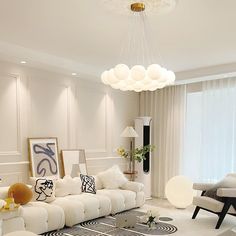 a modern living room with white furniture and art on the walls