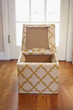 an open box sitting on top of a wooden floor next to a door and window