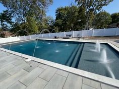 an empty swimming pool surrounded by white fence