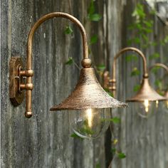 an old fashioned light fixture on the side of a wooden wall with ivy growing around it