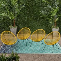 four yellow chairs sitting on top of a blue rug in front of some green plants