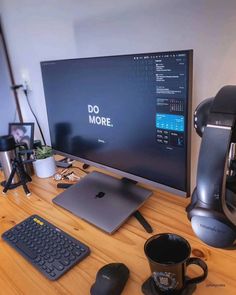 a computer monitor sitting on top of a wooden desk next to a keyboard and mouse