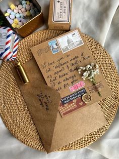 an envelope is on top of a wicker tray with some candy in the background