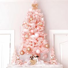 a pink christmas tree decorated with ornaments