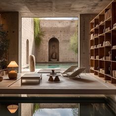 an indoor swimming pool surrounded by bookshelves and tables with lamps on each side