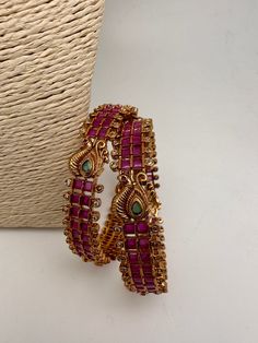 Traditional Bangles comes in set of 2Color : GoldenSize : Size : 2.4Stones : AD Red Green Stone Red Bohemian Bangle For Festive Season, Festive Red Bohemian Bangle, Red Metal Bangle For Party, Red Ruby Bracelet For Festive Occasions, Festive Red Ruby Bangle, Festive Red Ruby Bracelet, Festive Red Jewelry With Peacock Design, Red Ruby Bangle For Festive Occasions, Festive Red Metal Bangle