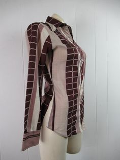 "Vintage 1970s women's disco shirt, mod blouse. Made of polyester. Color is burgundy and white. Has button down front and button cuffs. Made by Stitches. About a size medium. Actual measurements are: 35\" around the bust 30\" around the waist 14\" shoulder seam to shoulder seam 22.5\" shoulder seam to end of cuff 27\" overall length In very good condition." Fitted Brown Cotton Blouse, Fitted Brown Shirt, Fitted Burgundy Shirt For Fall, 70s Inspired Fitted Cotton Tops, Fitted Burgundy Tops With Button Closure, Fitted Burgundy Top With Button Closure, Fitted Retro Print 70s Inspired Tops, Retro Fitted Brown Blouse, Fitted Retro Brown Blouse