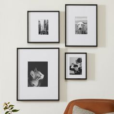 three black and white pictures hang on the wall above a brown chair with a pillow