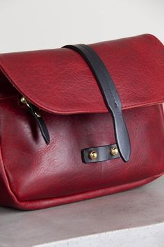 a red leather bag sitting on top of a counter