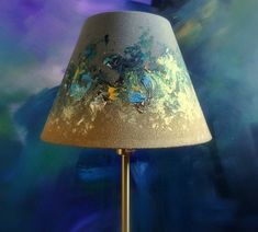 a lamp that is sitting on top of a table next to a blue and purple background