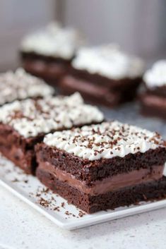 several pieces of chocolate cake with white frosting and sprinkles on a plate