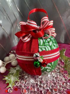 a green and red christmas ornament sitting on top of a pink table cloth