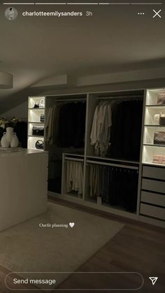 an open closet with white shelves and drawers