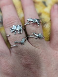 RAWR!  Introducing our stylish and unique adjustable dinosaur fashion rings, the perfect accessory for any occasion! Crafted with attention to detail, this elegant piece features an intricate design that wraps around your finger, adding a touch of sophistication to your look. Made from high-quality materials, it's durable and comfortable to wear.  Treat yourself or surprise a loved one with this timeless accessory that is sure to add a unique twist to your everyday style. Order yours today and e Dinosaur Accessories, Dinasour Rings, Cute Dinosaur Rings, Dinosaur Necklaces, Dinosaur Ring, Dinosaur Bone Ring, Handmade Fashion Jewelry, Handcrafted Rings, Unisex Jewelry