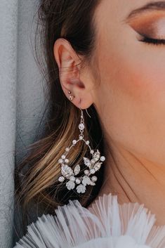 This beautiful hand-wired earring has tiny pearl and crystal beads, with white floral details. Elegant Jeweled Beaded Drop Earrings, Elegant White Flower Shaped Beaded Earrings, Elegant Flower Beaded Earrings For Wedding, Elegant White Crystal Flower Earrings, Elegant Wedding Flower Earrings With Ear Wire, Elegant White Jeweled Earrings, Jeweled Dangle Beaded Earrings For Wedding, Jeweled Beaded Dangle Earrings For Wedding, White Crystal Embellished Dangle Bridal Earrings