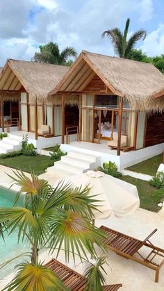 a couple of huts sitting next to a swimming pool