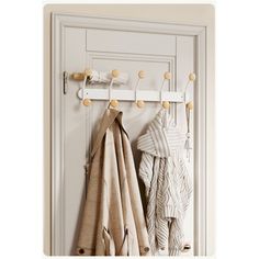 two coats hanging on hooks in front of a white door with an open coat rack