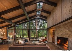 a living room filled with furniture and a fire place in front of a window covered wall