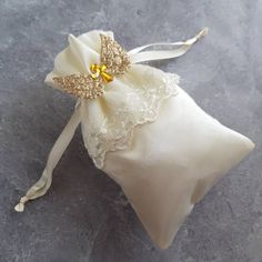 Satin Pouch with Lace Skirt is embellished with Wings and Cross. It's classic with ethereal feel. Best for Baptism, First Communion, Confirmation, Birthdays, Religious Gifts, Baby Shower Available in 3 Colors: 1. White Pouch with White Wings and Silver Cross 2. Ivory Pouch with Ivory Wings and Gold Cross 3. Ivory Pouch with Gold Wings and Gold Cross Size: 6x4 Order quantity: 10 pcs per pack Elegant Gold Baptism Dress, Elegant Beige Baptism Dress For Wedding, Elegant White Embroidered Baptism Dress, Elegant Cream Embroidered Baptism Dress, Satin Pouch, White Wings, Gifts Baby, Gold Cross, Religious Gifts