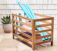 a wooden chair sitting on top of a tiled floor next to a potted plant