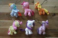 small crocheted ponys are on a wooden table with string attached to them