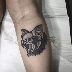 a black and white tattoo on the leg of a man with an angry wolf head