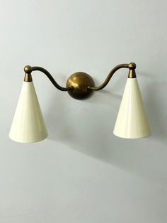 This brass double sconce wall lamp is a stylish and functional lighting fixture designed to add an elegant touch to any room in your home. Crafted from high quality brass this wall lamp features two individual sconces that extend outwards from the wall each with its own light source. The warm raw brass finish of the brass material lend a timeless and classic look to the lamp Whether you're looking to add some extra lighting to your bedroom living room or home office a brass double sconce wall la Barn Remodel, Brass Wall Lamp, Lamp Handmade, Modern Wall Lamp, Brass Wall Light, Brass Lamp, Brass Chandelier, Brass Wall, Light Sconces