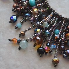 an assortment of beaded necklaces on a table