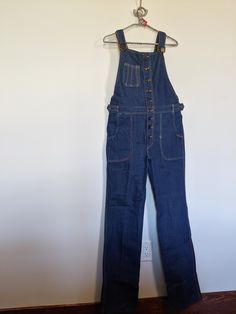 "Vintage Frederick's of Hollywood 1970's Overalls, 100% Cotton- No- Stretch, Adjustable Shoulder Straps Zipper Front, Two Setting Button Flaps at Waist,  Mint Vintage Condition, Never Worn or  Washed, Tag Reads L 31, Flat Measurements: Waist 32\" 1st.Button , 2nd Button 28\" 9 Front Buttons, Inseam 34\", 22\" Top Of Bid to Crotch, 34\" Hips, 8\" Wide Bottom Leg  Shoulder Strap Length 16\" to 29\" Very Cute. (909)" Vintage Spring Workwear Overalls, Retro Fall Jeans With Button Closure, Retro Flare Jeans For Fall, Retro Straight Leg Overalls With Pockets, Retro Medium Wash Jeans With Buttons, Retro High-rise Jeans With Button Closure, Retro High Rise Jeans With Button Closure, Retro Bib Front Overalls In Medium Wash, Retro Medium Wash Bib Front Overalls