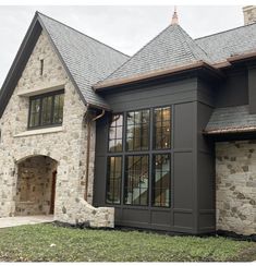 a house with stone walls and windows on the front side, along with a brick walkway leading up to it