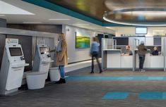 people are standing in an airport lobby near atm machines