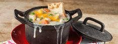 a pot filled with food sitting on top of a red plate